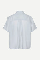 Samsoe Samsoe women’s light blue short sleeve shirt with minimalist Scandinavian design, relaxed silhouette and lightweight textured fabric, perfect for elegant everyday outfits and modern summer styling — γυναικείο γαλάζιο κοντομάνικο πουκάμισο Samsoe Samsoe με minimal Scandinavian αισθητική, χαλαρή γραμμή και ανάλαφρο ύφασμα για κομψά καθημερινά looks. Διαθέσιμο στο Iconic Angels Glyfada.