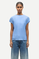 Light blue pleated short sleeve top with fluid silhouette and minimal neckline, offering soft movement and modern elegance — γαλάζιο πλισέ τοπ με κοντό μανίκι και αέρινη γραμμή, ιδανικό για chic casual, office και elevated summer looks με minimal αισθητική. Διαθέσιμο στο Iconic Angels Glyfada.