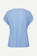 Light blue pleated short sleeve top with fluid silhouette and minimal neckline, offering soft movement and modern elegance — γαλάζιο πλισέ τοπ με κοντό μανίκι και αέρινη γραμμή, ιδανικό για chic casual, office και elevated summer looks με minimal αισθητική. Διαθέσιμο στο Iconic Angels Glyfada.