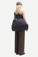 Olive green pleated wide leg trousers with elastic waistband and fluid silhouette, offering relaxed elegance and movement — χακί πλισέ παντελόνα σε wide leg γραμμή με ελαστική μέση και αέρινη εφαρμογή, ιδανική για minimal chic, office και elevated everyday looks. Διαθέσιμη στο Iconic Angels Glyfada.