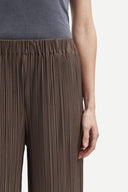 Olive green pleated wide leg trousers with elastic waistband and fluid silhouette, offering relaxed elegance and movement — χακί πλισέ παντελόνα σε wide leg γραμμή με ελαστική μέση και αέρινη εφαρμογή, ιδανική για minimal chic, office και elevated everyday looks. Διαθέσιμη στο Iconic Angels Glyfada.
